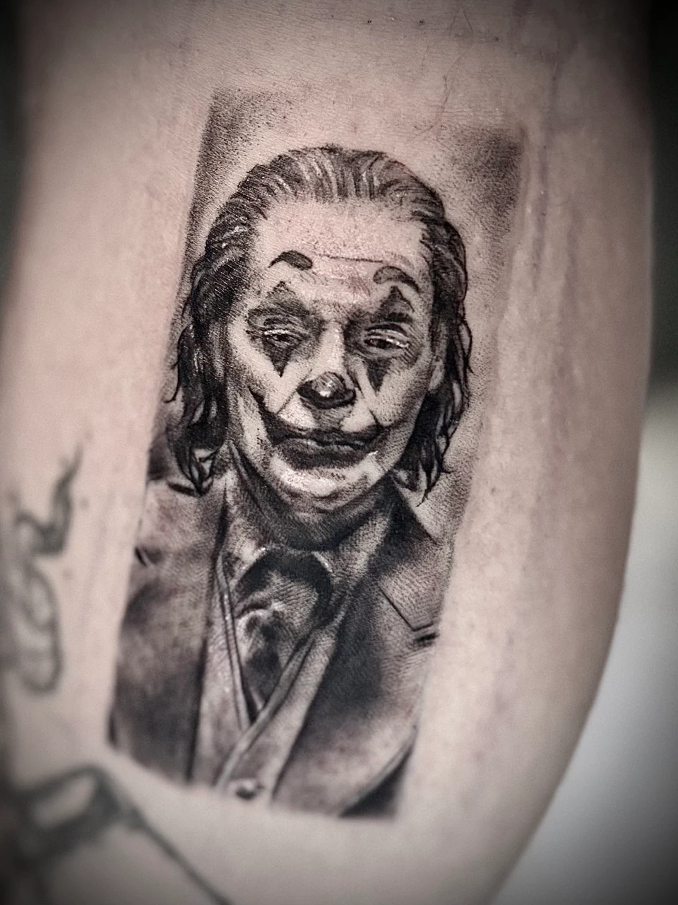 Detailreiches realistisches Joker Tattoo auf der Wade, gestochen von ON Tattoo Artist Freiburg, Ton und Tinte.